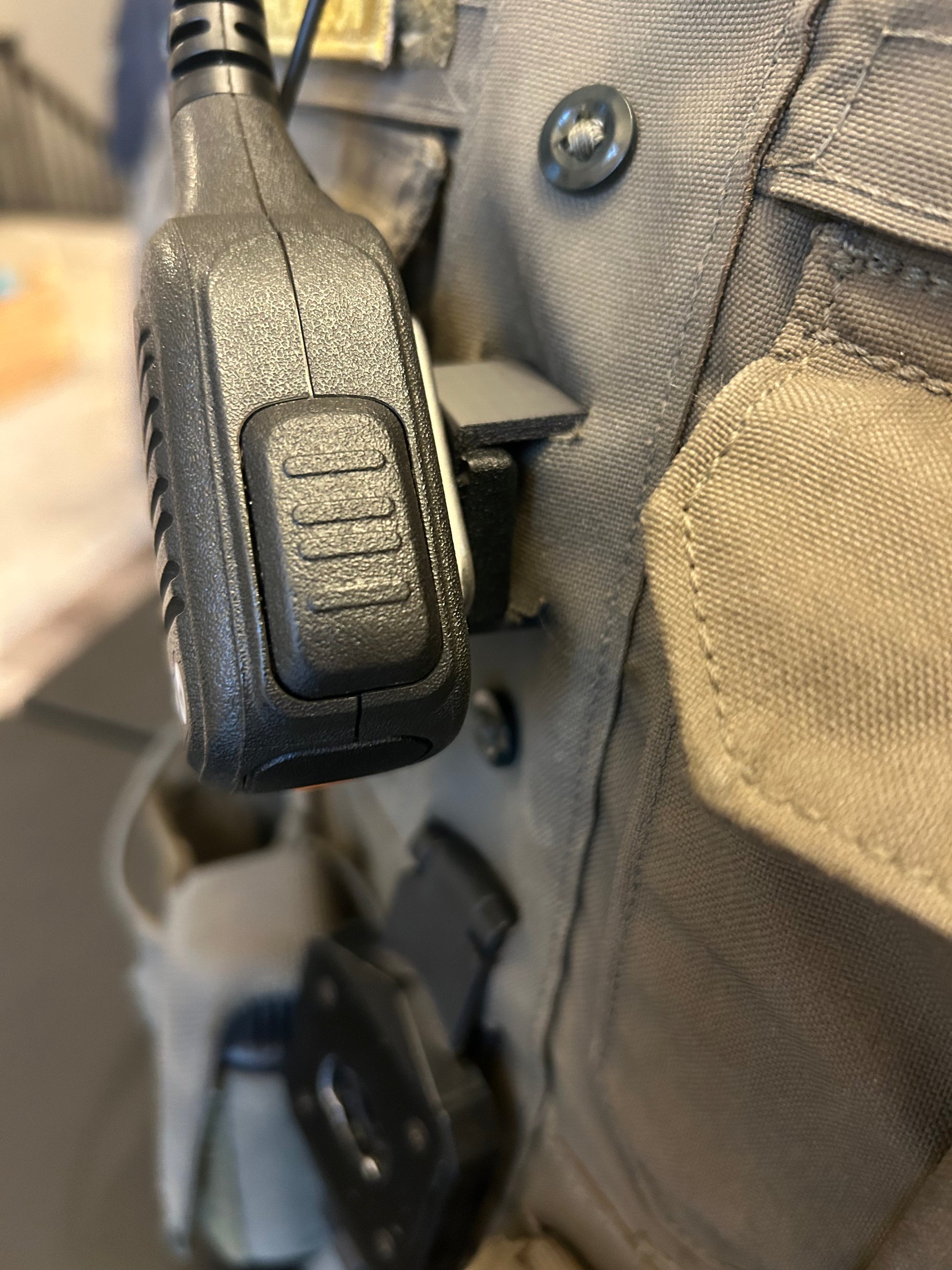 Motorola hand mic held on by molle mic clip for police officers